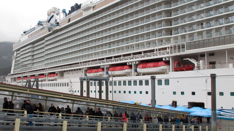 Passengers stream off the Norwegian Bliss after the vessel arrived...