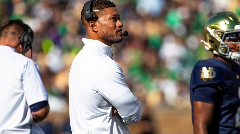 Notre Dame head coach Marcus Freeman looks to the scoreboard...