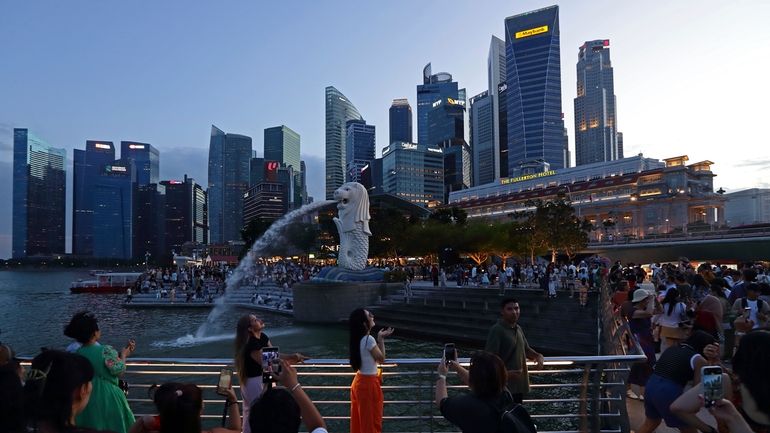 People take photos at Merlion Park in Singapore, Saturday, Sept....