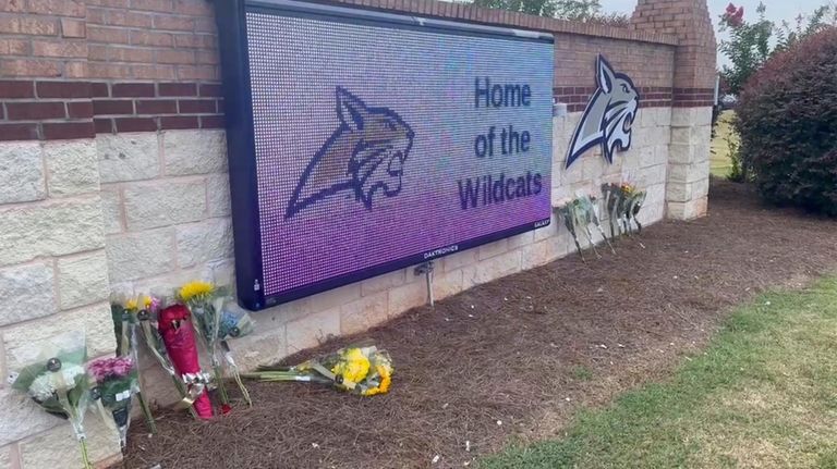 Flowers are placed outside the entrance to Apalachee High School...