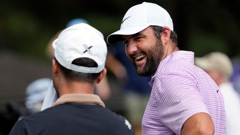 Scottie Scheffler, right, laughs with Xander Schauffele as they wait...