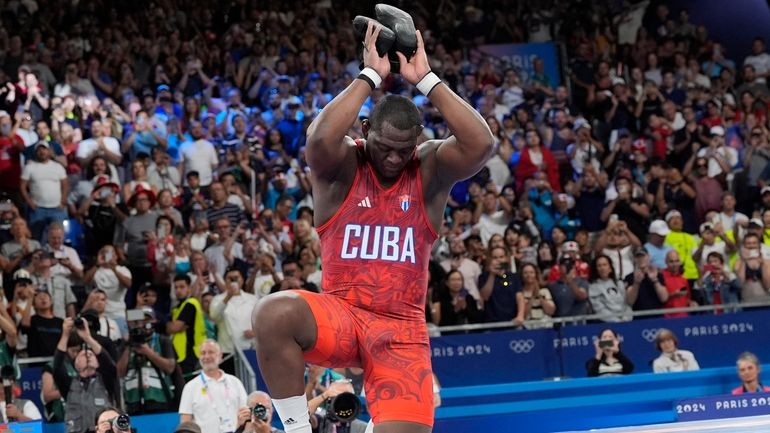 Cuba's Mijain Lopez Nunez removes his shoes as a signal...