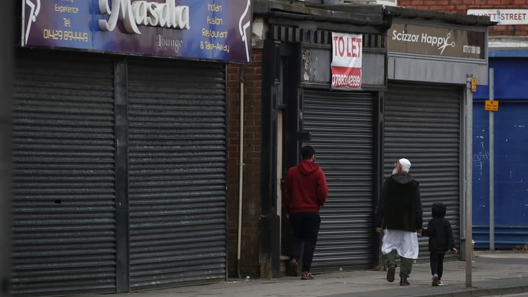 People walk past some shuttered and closed shops in Hartlepool...