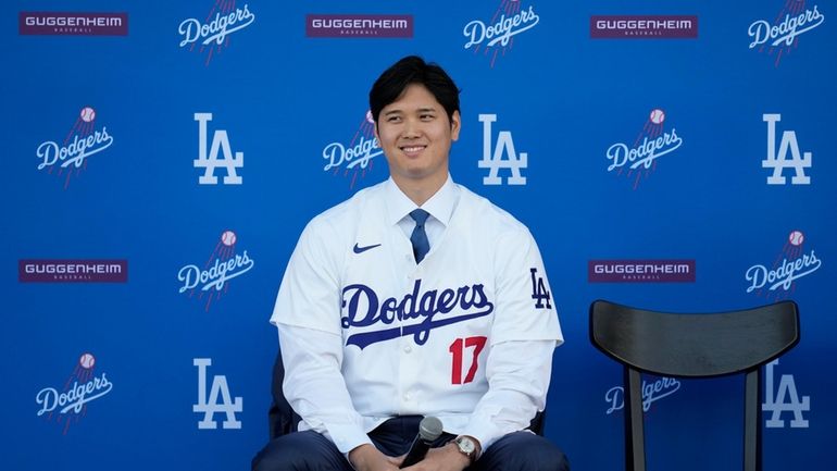 Los Angeles Dodgers' Shohei Ohtani answers questions during a baseball...