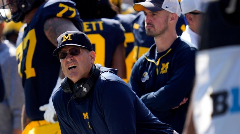 Michigan head coach Jim Harbaugh, front left, watches against Rutgers...