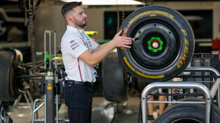 A Mercedes mechanic inspects a tire ahead of the Qatar...