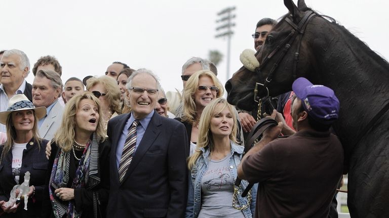 Race horse owner Jerry Moss, center, his wife Ann, center...