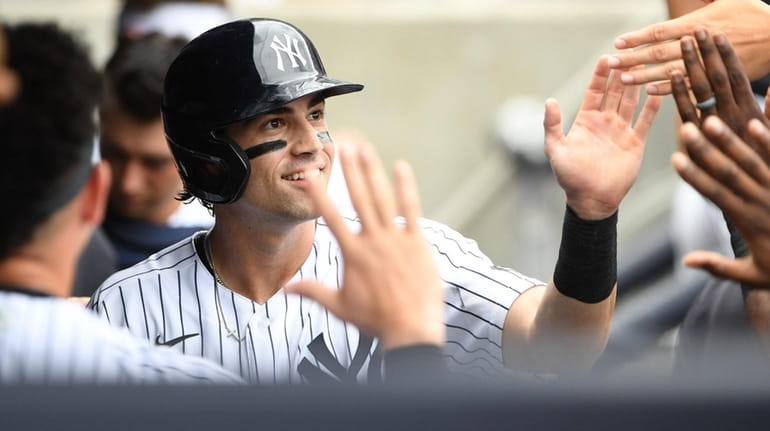 Yankees leftfielder Tyler Wade is greeted in the dugout after...