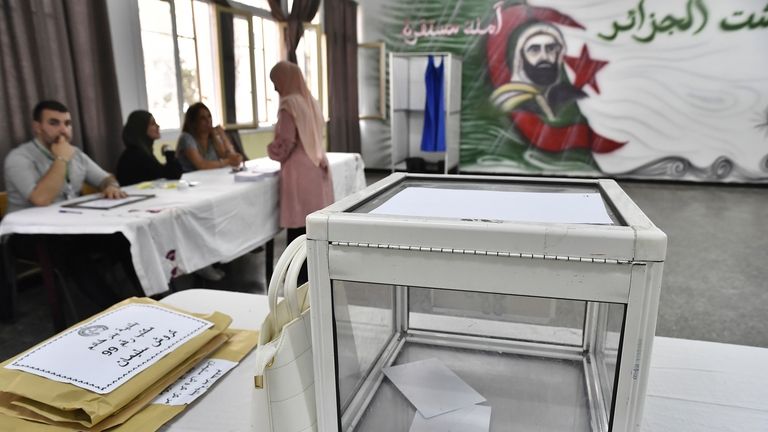 Election officials wait for voters inside a polling station during...