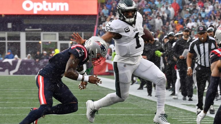 Philadelphia Eagles quarterback Jalen Hurts (1) is pursued by New...