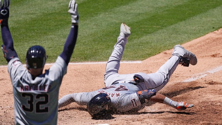 Detroit Tigers' Justyn-Henry Malloy, right, scores on an inside-the-park home...
