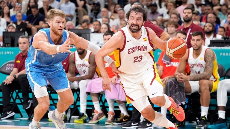 Sergio Llull, right, of Spain,, right, drives by Thomas Walkup,...