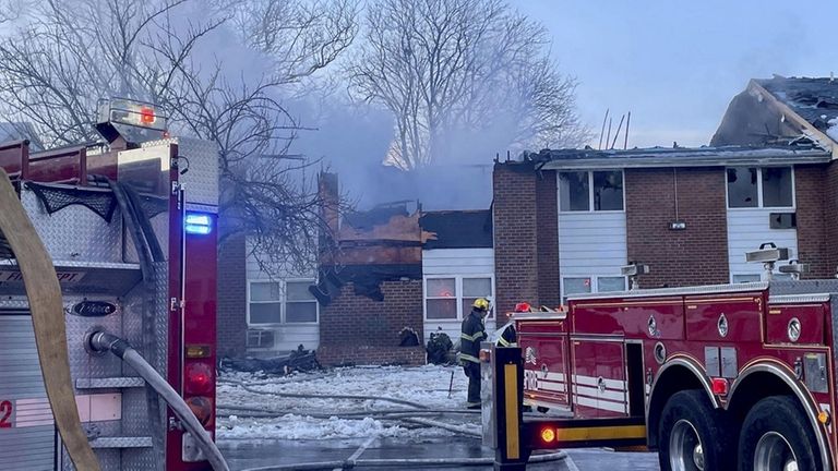 Thick smoke billows up from a burning unit at a...