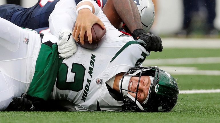 Zach Wilson #2 of the Jets is sacked by Anfernee...