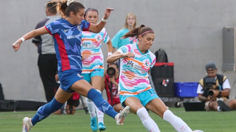 San Diego Wave's Alex Morgan, right, battles for the ball...