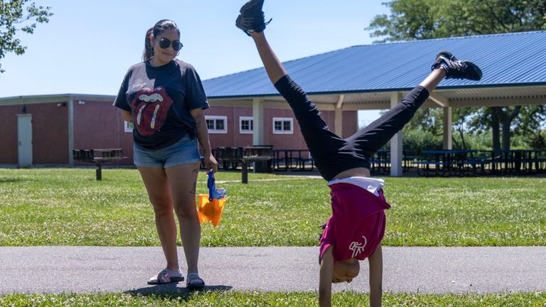 Erika Arriaza, of Freeport, watches her daughter Mileni do cartwheels...