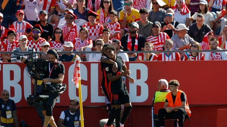 Barcelona's Lamine Yamal, right, celebrates with his teammate after scoring...