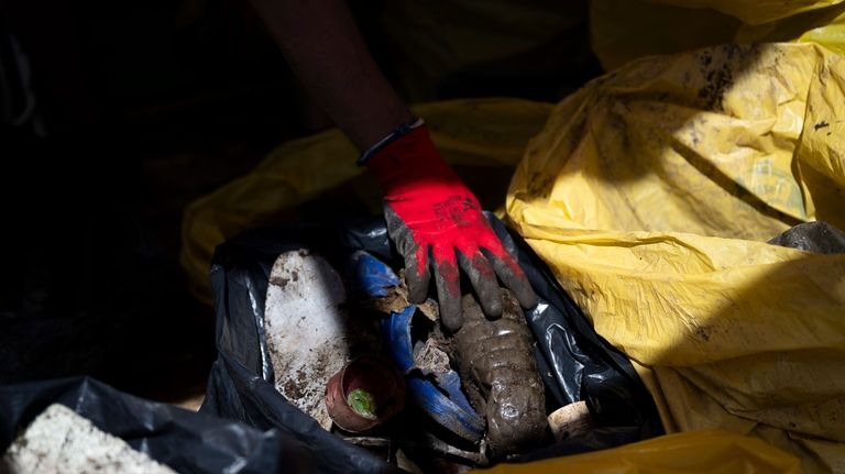 Volunteers sort the collected rubbish on their boat while attending...