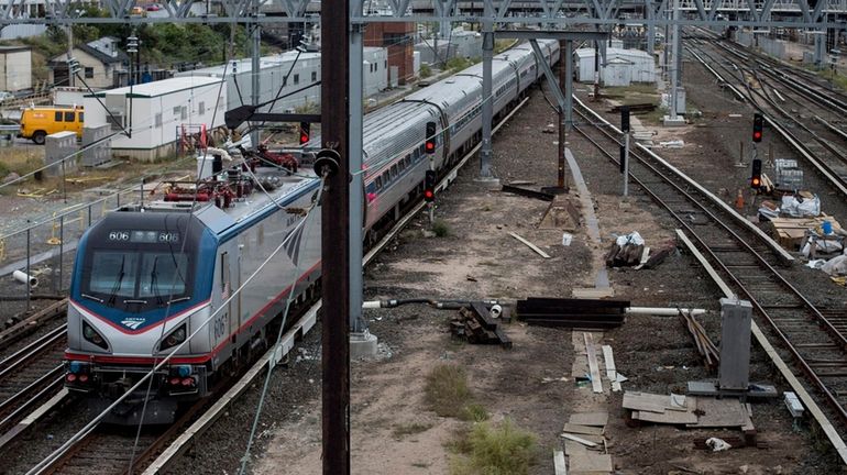 An Amtrak train rolls through the Harold Interlocking in Long...