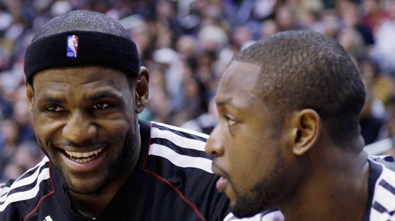 LeBron James talks with Dwyane Wade during the first half...
