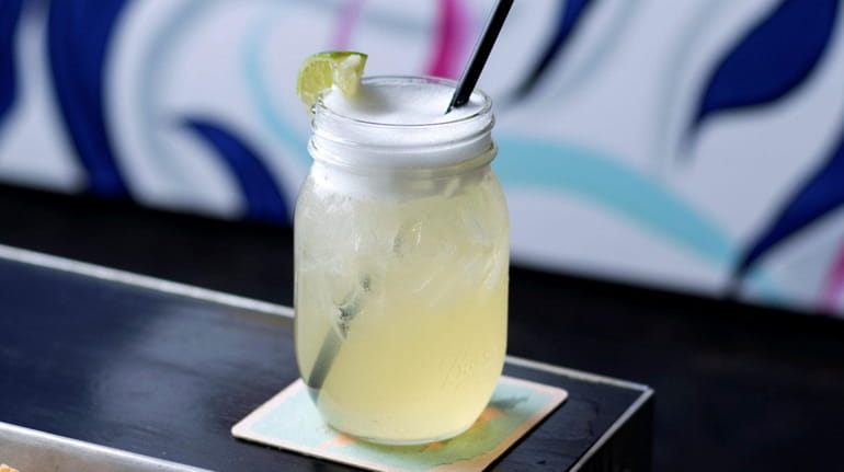 Margaritas are served in a mason jar with a soft...