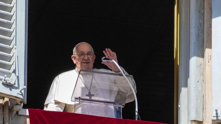 Pope Francis appears at the window of his studio overlooking...