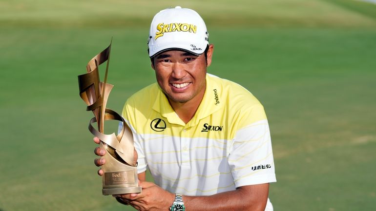 Hideki Matsuyama, of Japan, holds his trophy after winning the...