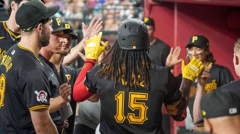 Pittsburgh Pirates' Oneil Cruz (15) gets high-fives from teammates after...