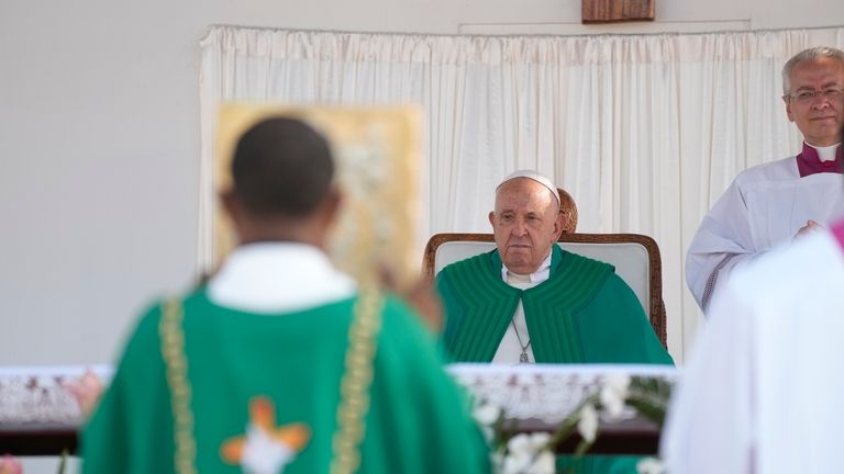 Pope Francis, flanked by Archbishop Diego Ravelli, right, presides over...