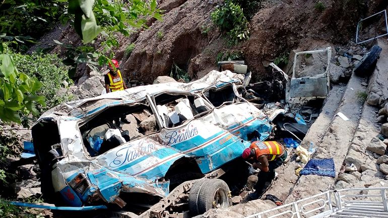 Rescue workers look for the victims and wounded passengers from...