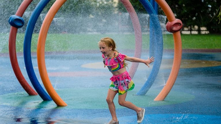 Lilly Smilardi 6 of Bellmore runs through the sprinklers at...