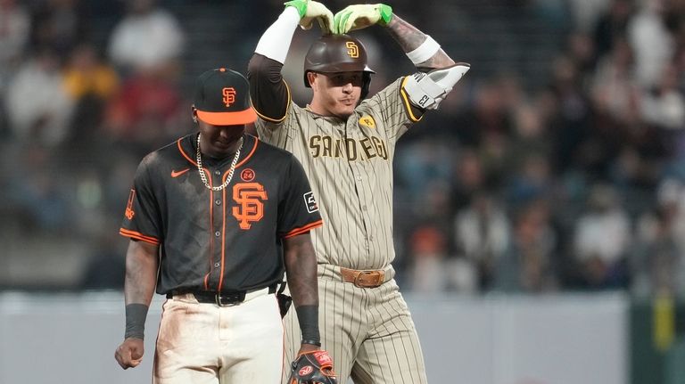 San Diego Padres' Manny Machado, right, gestures next to San...