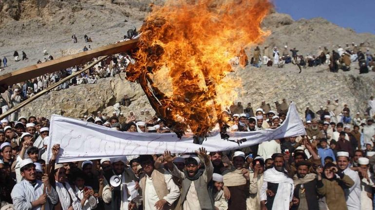 Afghans burn an effigy representing U.S. President Barack Obama during...