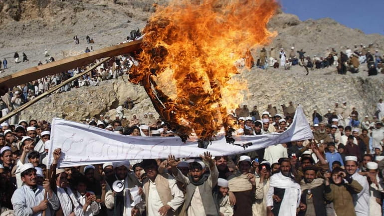 Afghans burn an effigy representing U.S. President Barack Obama during...