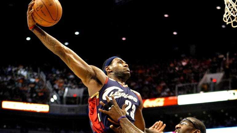 Cavaliers' LeBron James dunks over Phoenix Suns' Amar'e Stoudemire. (Dec....