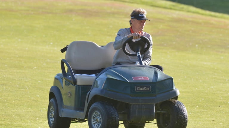 Bernhard Langer uses a cart on the first hole during...