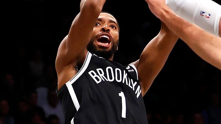 Nets forward Mikal Bridges shoots over Bucks center Brook Lopez...