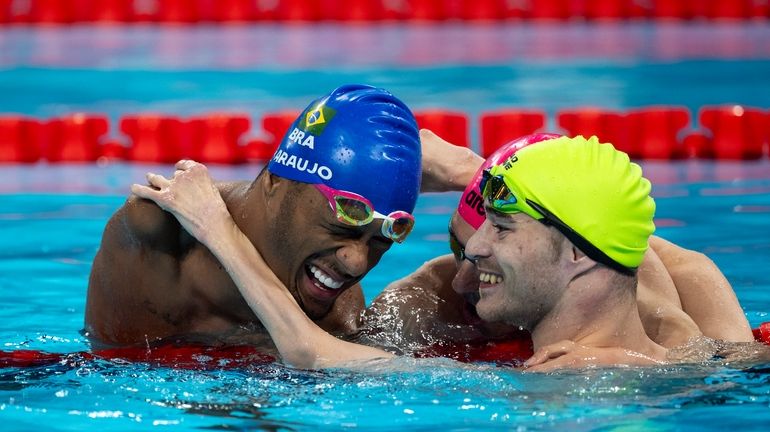 Paralympic athlete Araujo dos Santos, of Brasil, left, celebrates his...