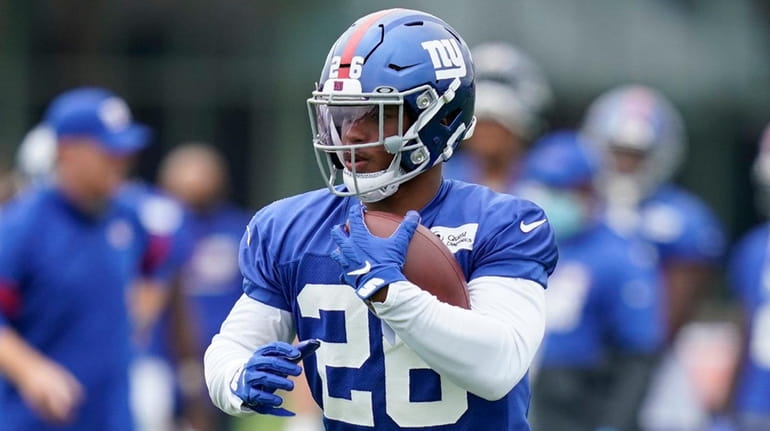 The Giants' Saquon Barkley runs the ball during practice at...
