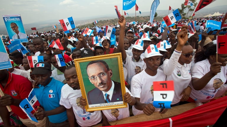Supporters of Rwanda's President Paul Kagame, portrait centre, attend an...