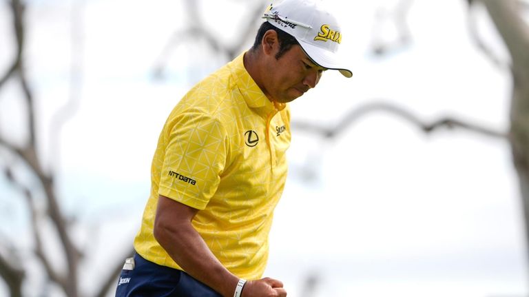 Hideki Matsuyama, of Japan, celebrates his shot on the 18th...