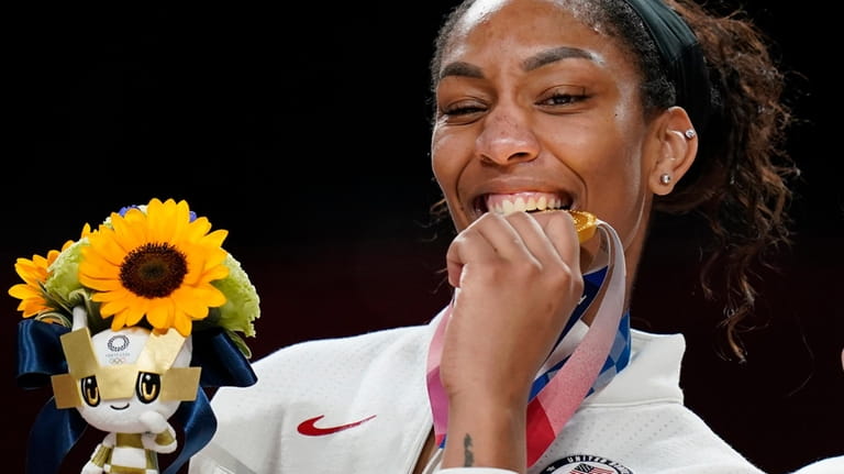 United State's A'Ja Wilson bites her gold medal during the...