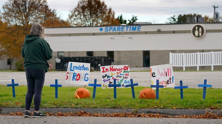 A woman visits a makeshift memorial outside Sparetime Bowling Alley,...