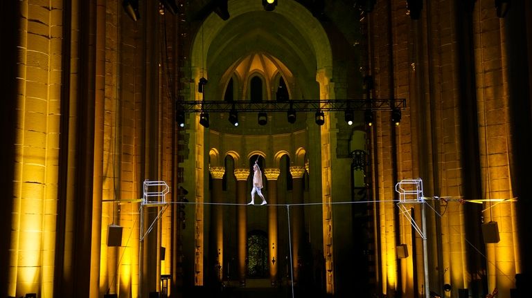 Philippe Petit walks a tightrope inside the Cathedral Church of...