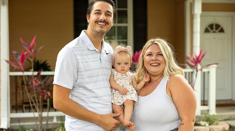 Sam Earle, left, poses with his wife, Tori, and their...