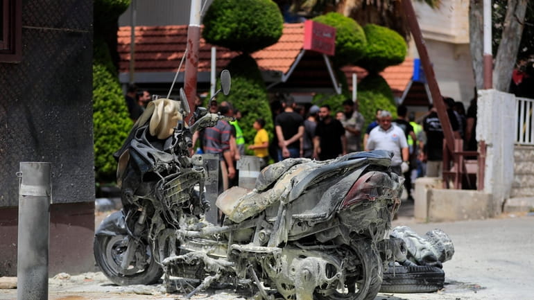 A charred motorcycle is seen after an Israeli strike outside...