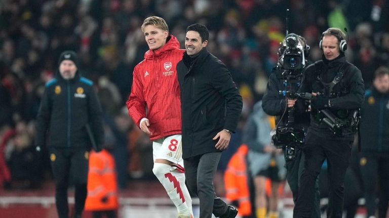 Arsenal's manager Mikel Arteta leaves the field with Arsenal's Martin...