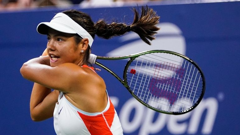 Emma Raducanu, of Britain, returns a shot to Alize Cornet,...