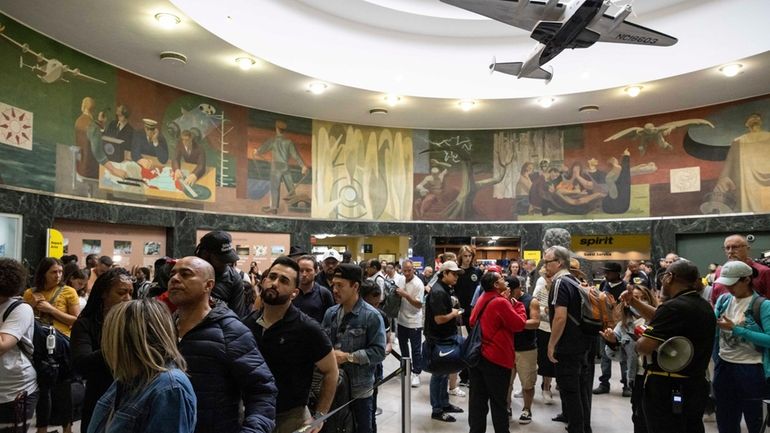 Customers wait in line at departure area for Spirit Airlines...