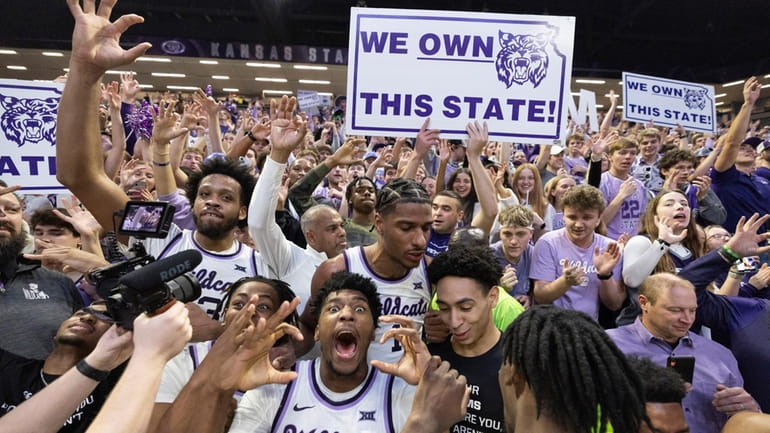 Kansas State players, including Jerrell Colbert (20), celebrate with fans...